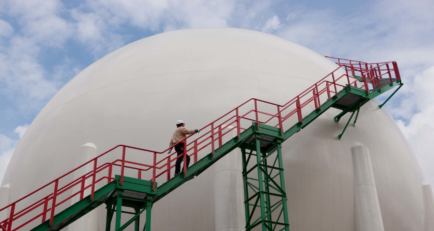 Operario con casco subiendo escaleras en refinería